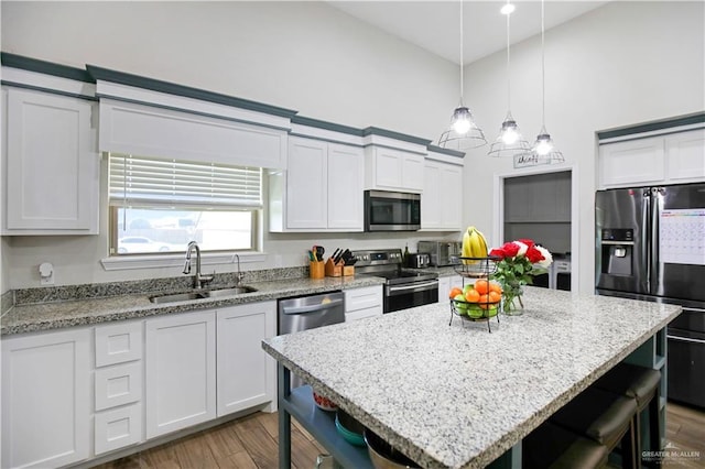 8718 Pink Flamingo St, Harlingen, TX 78552 - kitchen featuring stainless steel appliances, a sink, a breakfast bar area, light stone countertops, and a towering ceiling