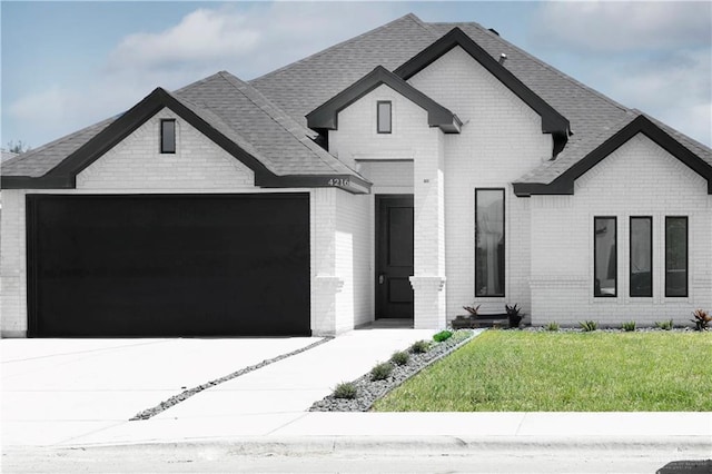 4216 Xenops Ave, Mcallen, TX 78504 - view of front of property featuring brick siding, an attached garage, concrete driveway, a front lawn, and roof with shingles