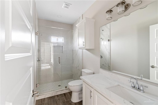 bathroom with vanity, toilet, wood-type flooring, and walk in shower