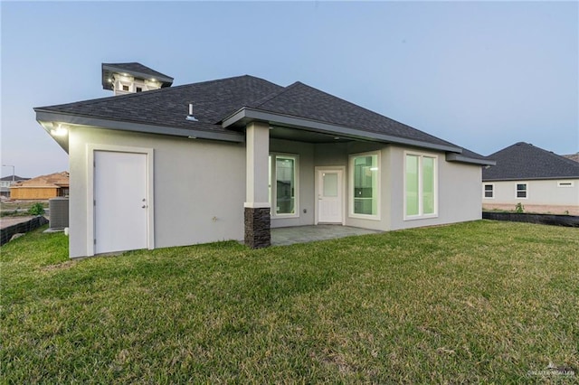 rear view of house with central air condition unit, a yard, and a patio