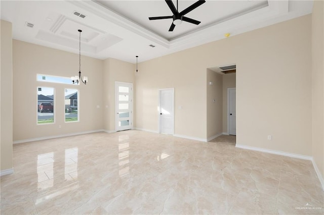 unfurnished room featuring ceiling fan with notable chandelier, a high ceiling, and a tray ceiling