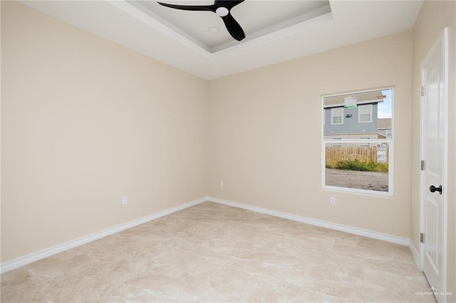 unfurnished room with a raised ceiling and ceiling fan