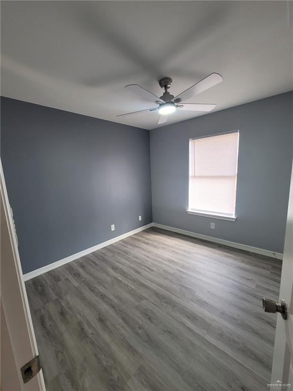 spare room with hardwood / wood-style flooring and ceiling fan