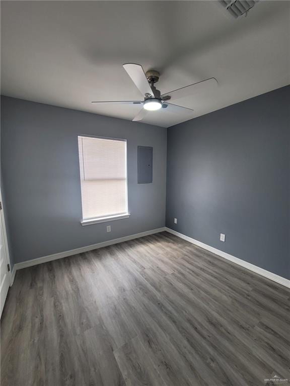 spare room featuring ceiling fan, dark hardwood / wood-style flooring, and electric panel