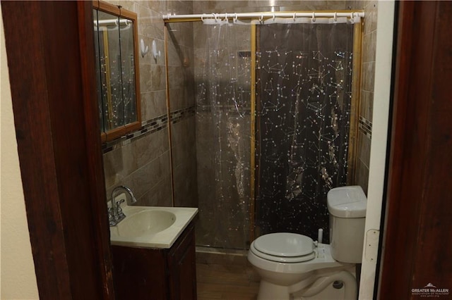 bathroom with toilet, vanity, a shower with curtain, and tile walls