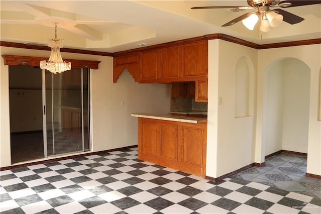 kitchen featuring ceiling fan with notable chandelier, pendant lighting, and a raised ceiling