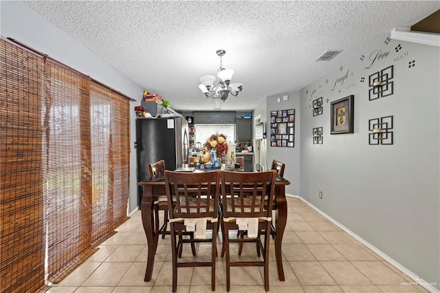 1729 W Jefferson St, Weslaco, TX 78599 - dining room with a chandelier, light tile patterned floors, and a textured ceiling