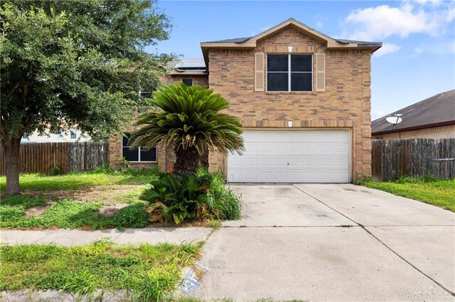 1729 W Jefferson St, Weslaco, TX 78599 - view of front facade featuring an attached garage, solar panels, brick siding, and concrete driveway