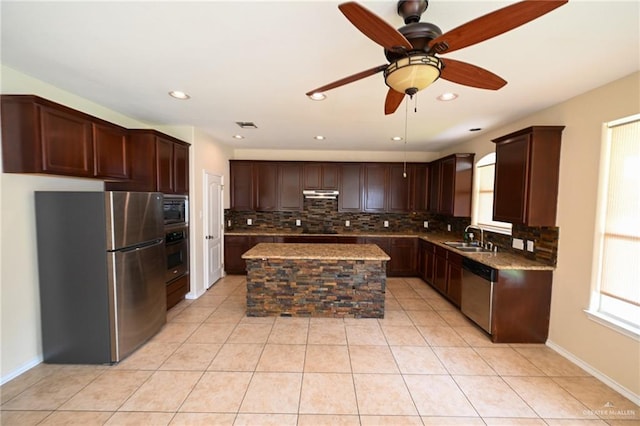 kitchen featuring sink, ceiling fan, tasteful backsplash, a kitchen island, and stainless steel appliances