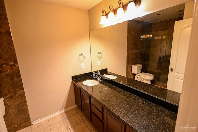 bathroom with tile patterned floors, vanity, an enclosed shower, and toilet