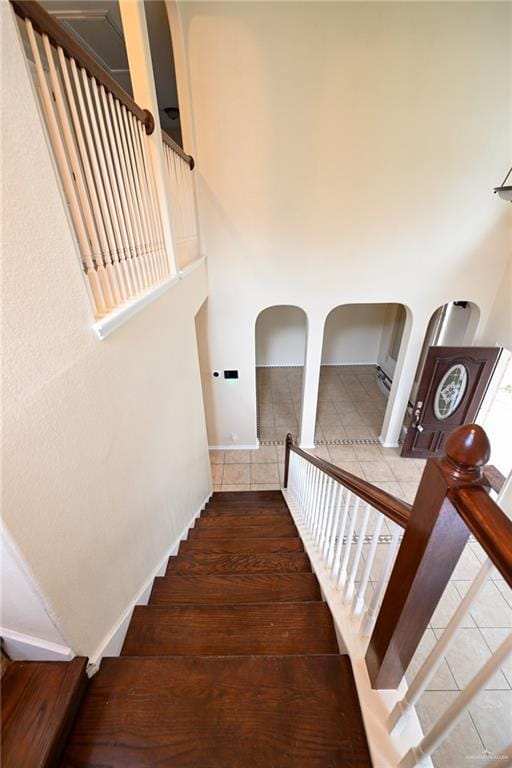 2316 Fairmont Ave, Mcallen, TX 78504 - staircase featuring tile patterned floors, arched walkways, and a high ceiling