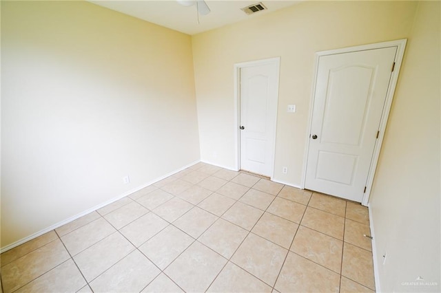 tiled spare room featuring ceiling fan