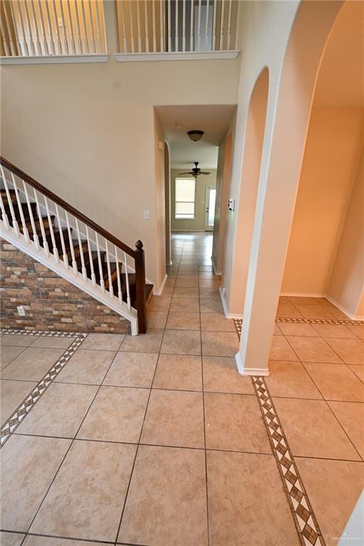 corridor with tile patterned flooring and a towering ceiling