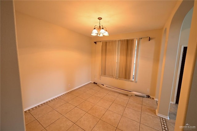 tiled empty room featuring a notable chandelier