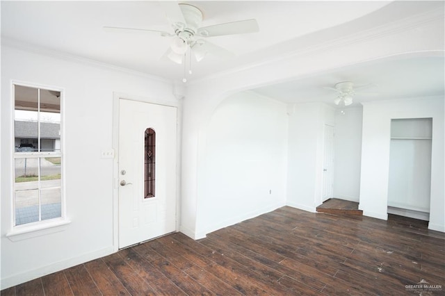 foyer entrance featuring dark wood-type flooring, ornamental molding, baseboards, and a ceiling fan