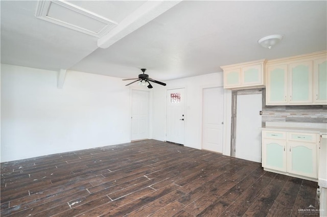 interior space with dark wood-style floors, attic access, and a ceiling fan