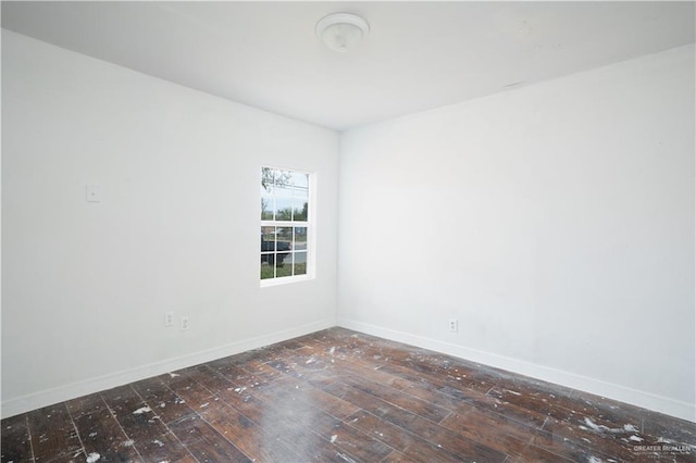 empty room with dark wood finished floors and baseboards