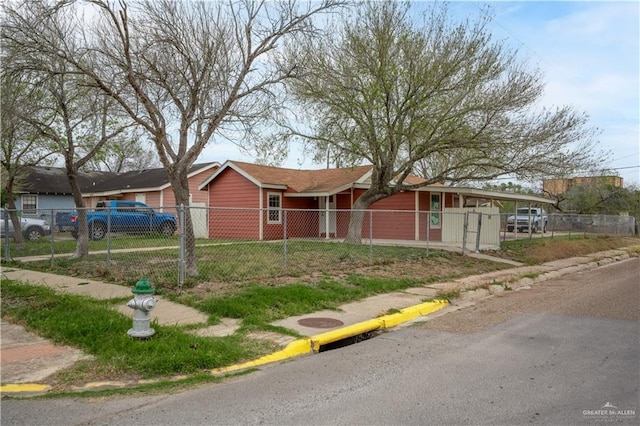 ranch-style home with a fenced front yard and a carport