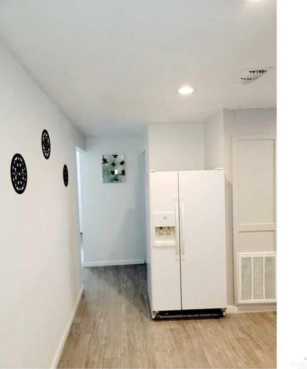 kitchen featuring white refrigerator with ice dispenser and light wood-type flooring