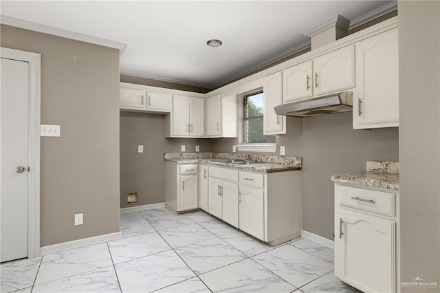 kitchen featuring white cabinets, light stone countertops, ornamental molding, and sink