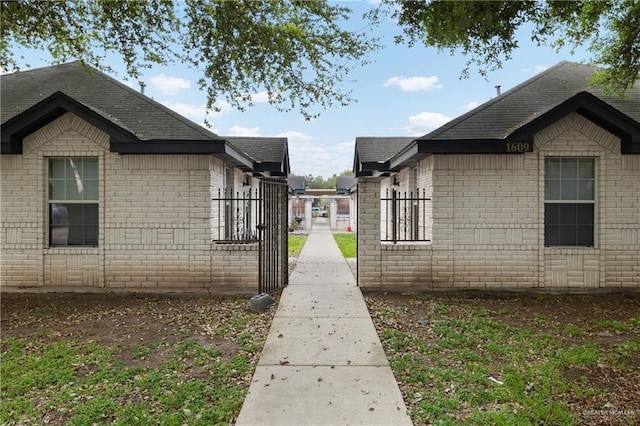 1609 Nassau St, Edinburg, TX 78541 - view of side of home featuring brick siding, fence, and a shingled roof