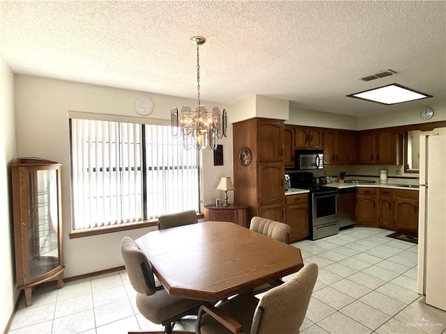 dining area featuring light tile patterned floors, a textured ceiling, and a notable chandelier