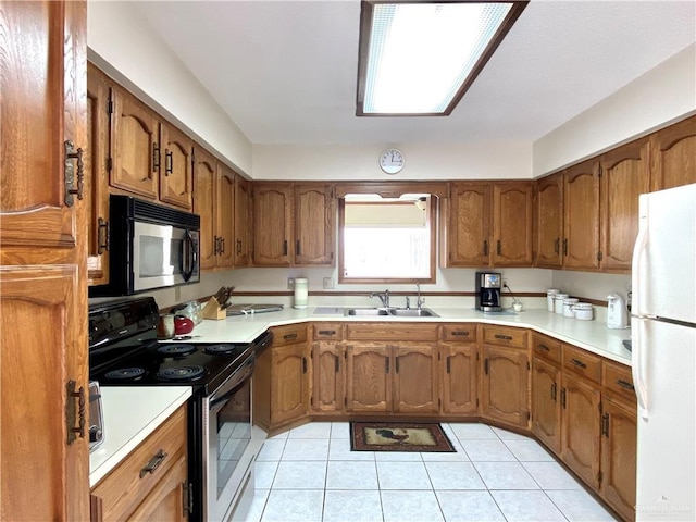 kitchen featuring white refrigerator, stainless steel electric stove, sink, and light tile patterned floors