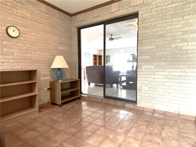 interior space featuring ceiling fan, brick wall, and ornamental molding