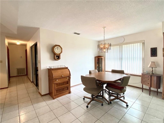 dining room with light tile patterned floors, a textured ceiling, and a notable chandelier