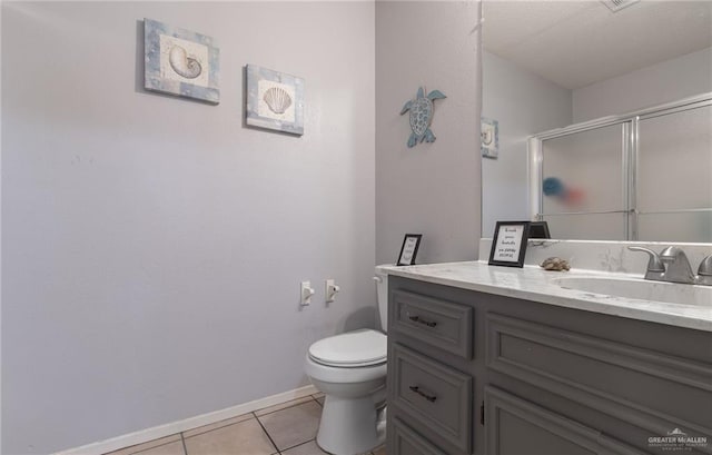 bathroom with toilet, vanity, tile patterned floors, and a shower with door