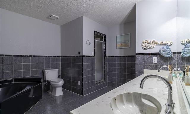 bathroom with tile walls, vanity, and a textured ceiling