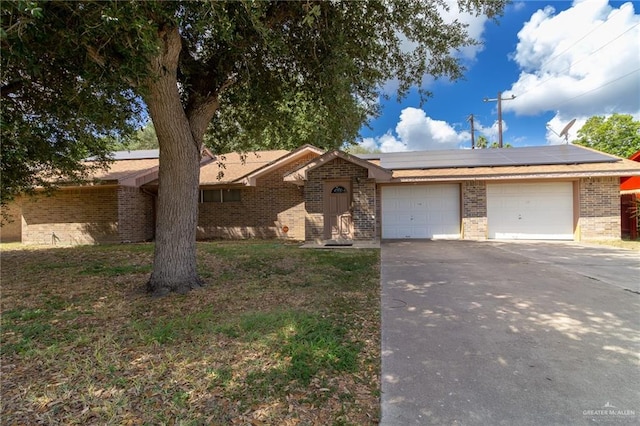 ranch-style house with solar panels and a garage