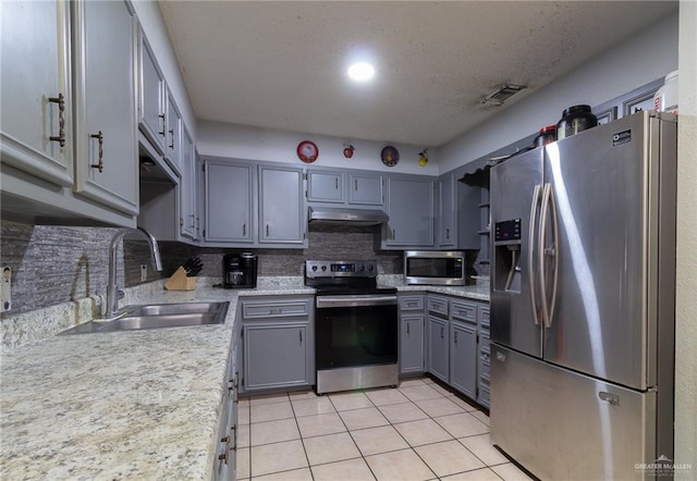 kitchen featuring sink, gray cabinets, tasteful backsplash, light tile patterned flooring, and stainless steel appliances