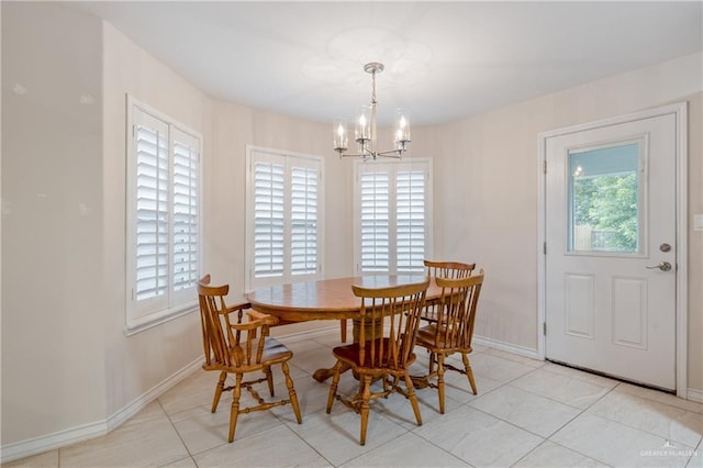 dining area with light tile patterned floors and an inviting chandelier