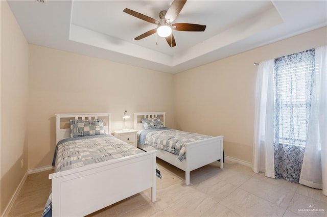 bedroom with a tray ceiling and ceiling fan