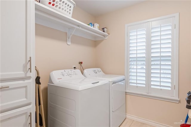 laundry room featuring independent washer and dryer and light tile patterned flooring