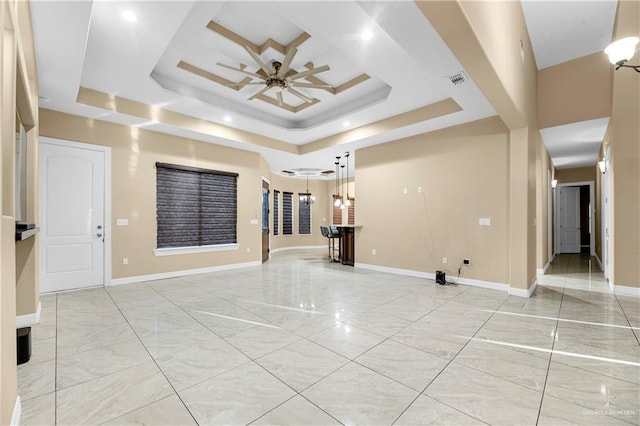 empty room featuring a raised ceiling and ceiling fan