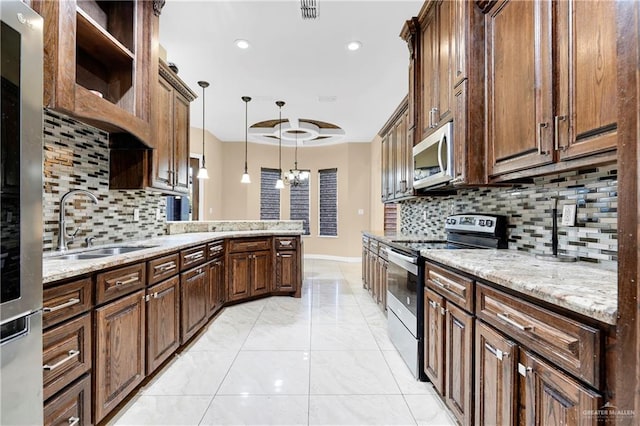 kitchen featuring decorative light fixtures, sink, appliances with stainless steel finishes, and tasteful backsplash