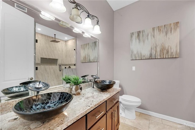 bathroom with tile patterned flooring, vanity, toilet, and walk in shower