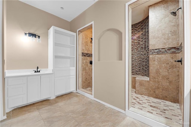 bathroom with vanity and tiled shower