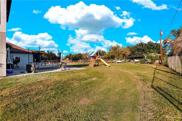 view of yard featuring a playground, a patio, and a trampoline