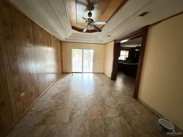 spare room featuring a tray ceiling, a wealth of natural light, and ceiling fan