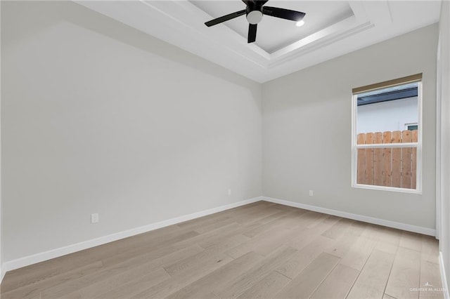 809 Azalea St, Mission, TX 78573 - unfurnished room with light wood-style flooring, a ceiling fan, a raised ceiling, and baseboards