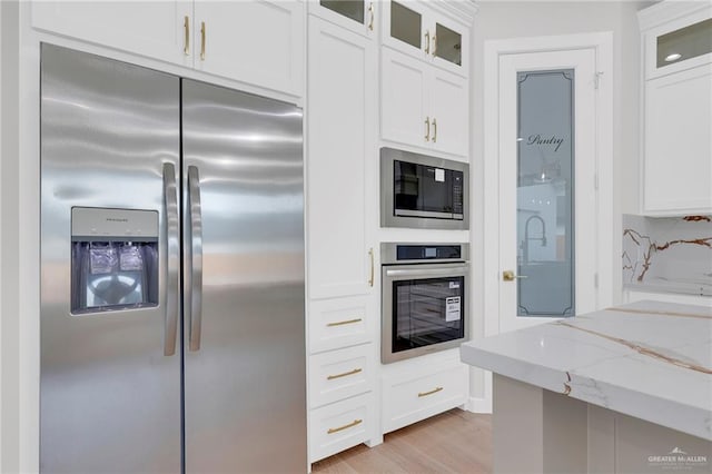 809 Azalea St, Mission, TX 78573 - kitchen with appliances with stainless steel finishes, light stone countertops, white cabinets, and glass insert cabinets