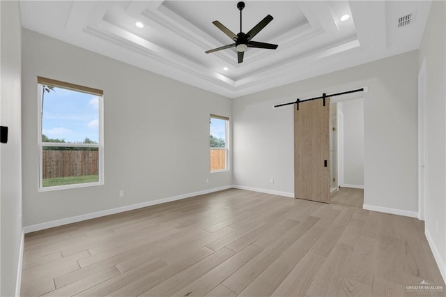 809 Azalea St, Mission, TX 78573 - unfurnished bedroom with a barn door, light wood-type flooring, a tray ceiling, baseboards, and recessed lighting
