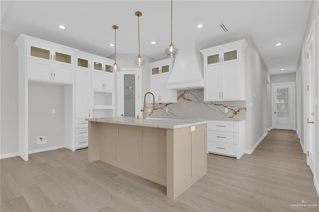809 Azalea St, Mission, TX 78573 - kitchen with light wood finished floors, a kitchen island with sink, recessed lighting, tasteful backsplash, and white cabinets