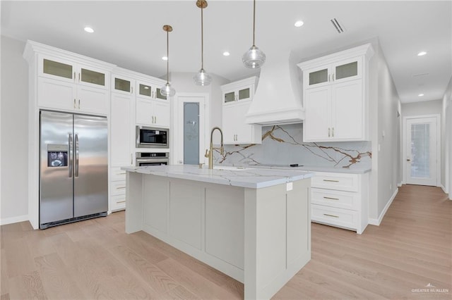 809 Azalea St, Mission, TX 78573 - kitchen with built in appliances, light wood-type flooring, custom range hood, tasteful backsplash, and recessed lighting
