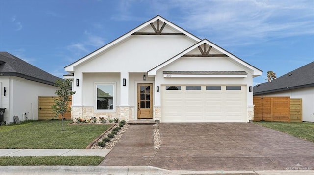 809 Azalea St, Mission, TX 78573 - view of front of property featuring driveway, a garage, stucco siding, and stone siding