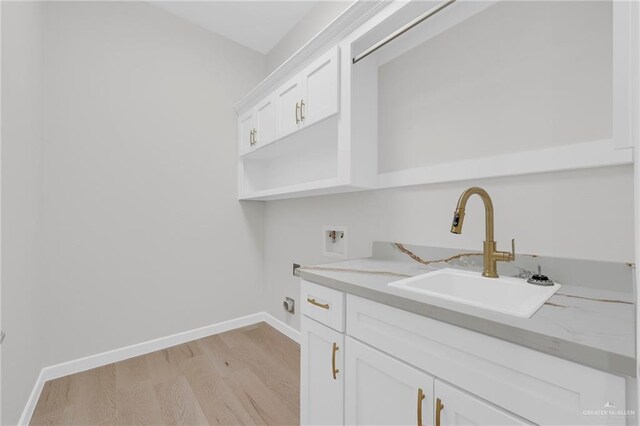 809 Azalea St, Mission, TX 78573 - laundry room with hookup for a washing machine, light wood-type flooring, cabinet space, baseboards, and electric dryer hookup