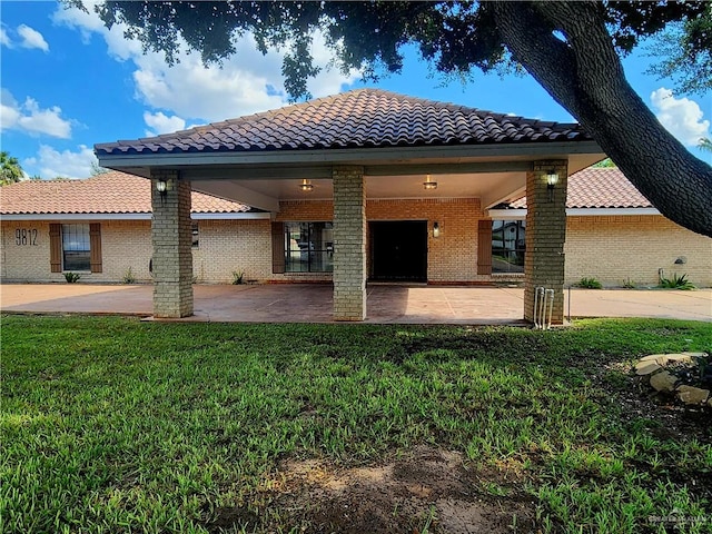 rear view of house featuring a yard and a patio